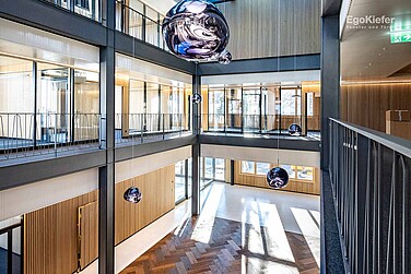 Vue intérieure de la transformation de la Clientis Biene Bank, avec un grand atrium transparent à l'intérieur du bâtiment