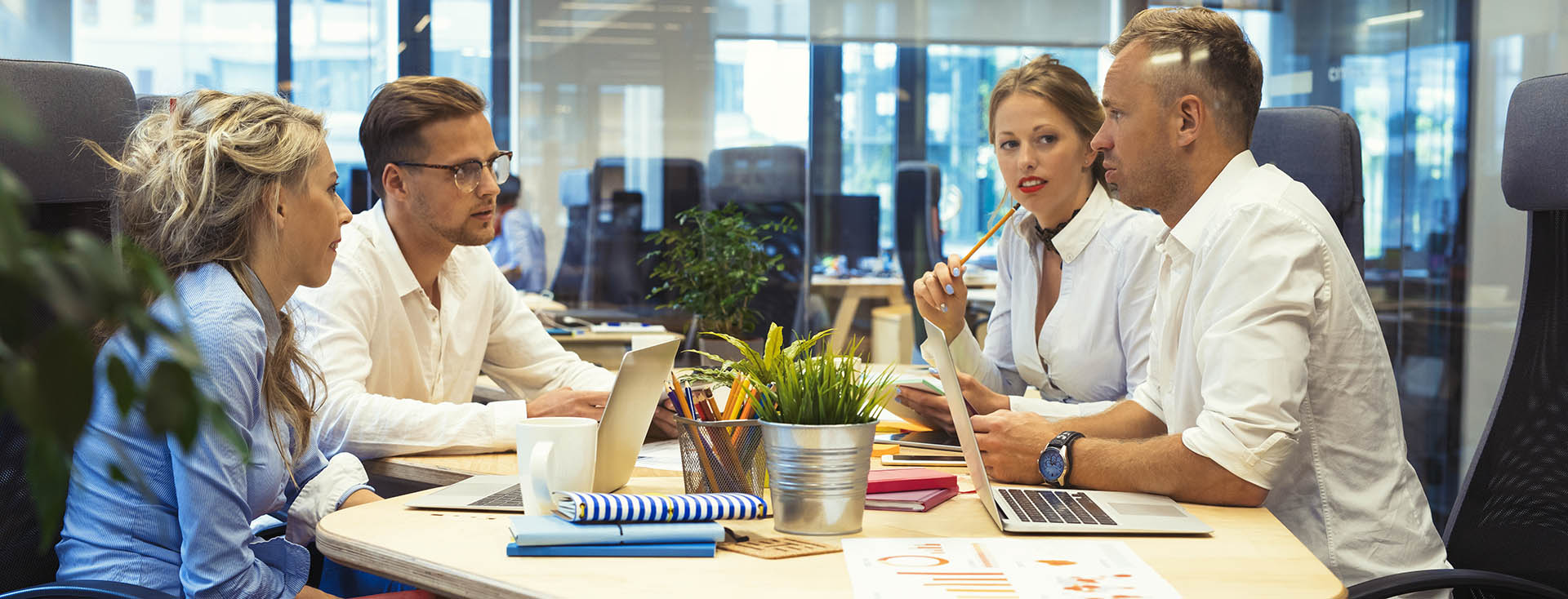 Gruppe von vier Personen bei einer Besprechung in einem modernen Büro