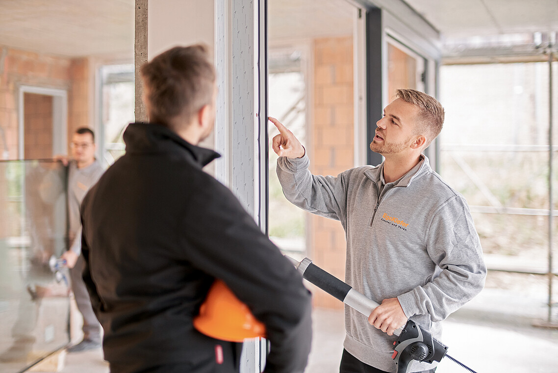 EgoKiefer Mitarbeiter eines Fachbetriebs montiert ein Fenster auf einer Hausbaustelle.