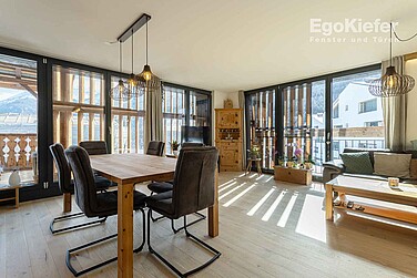 Appartement de vacances « Chasa Pütvia », photo d'intérieur dans le salon avec de grandes fenêtres en bois/aluminium EgoKiefer dans l'image