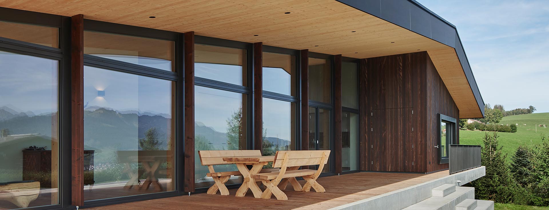 Terrazza in legno moderna con gruppo di sedute e vista panoramica sul paesaggio