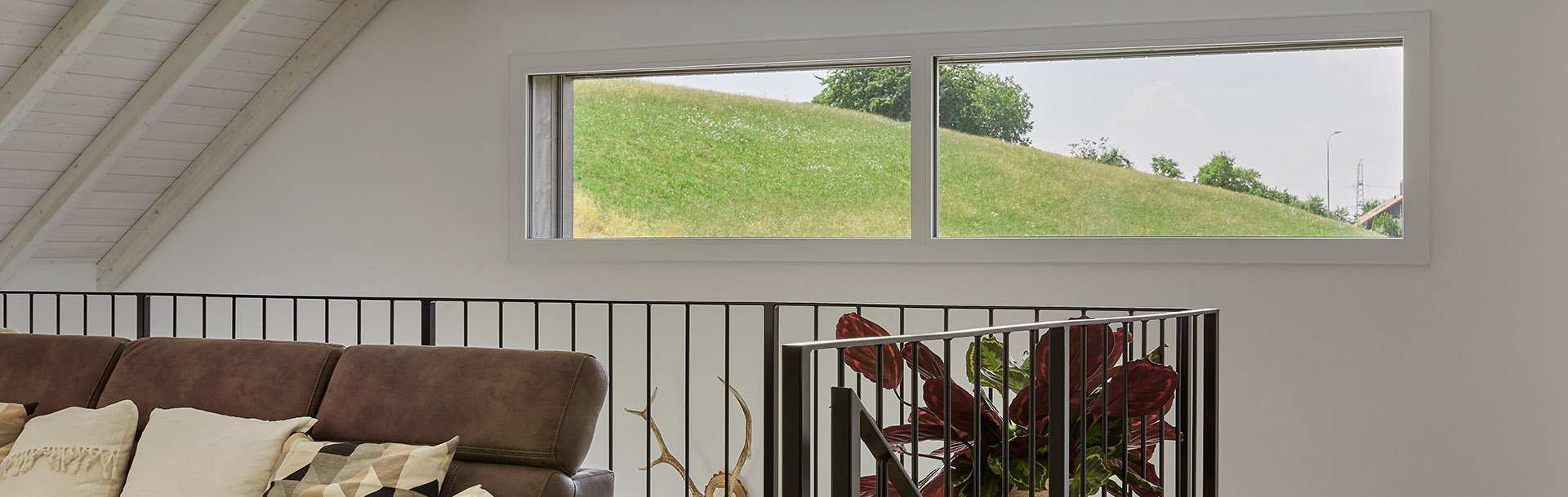 Modernes Wohnzimmer mit großem Fenster und Blick ins Grüne